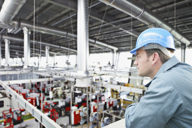 Arbeiter blick auf eine Lüftungsanlage in einer Fabrikhalle